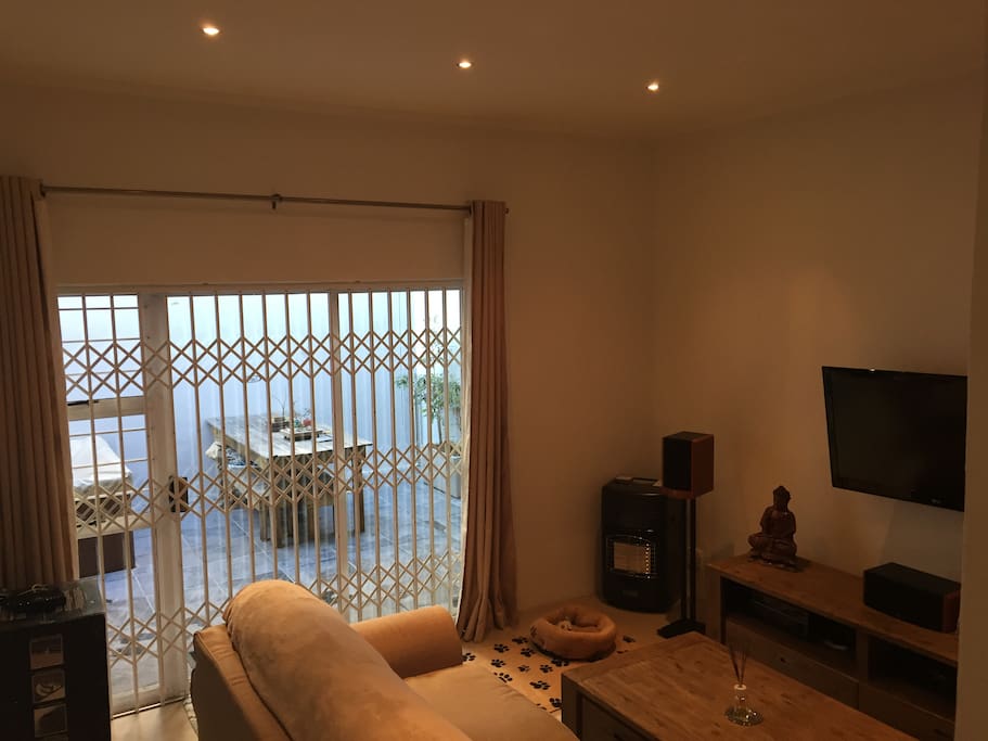 Spacious, contemporary living room with entertainment system and satellite TV - Leads on to private courtyard with Jacuzzi