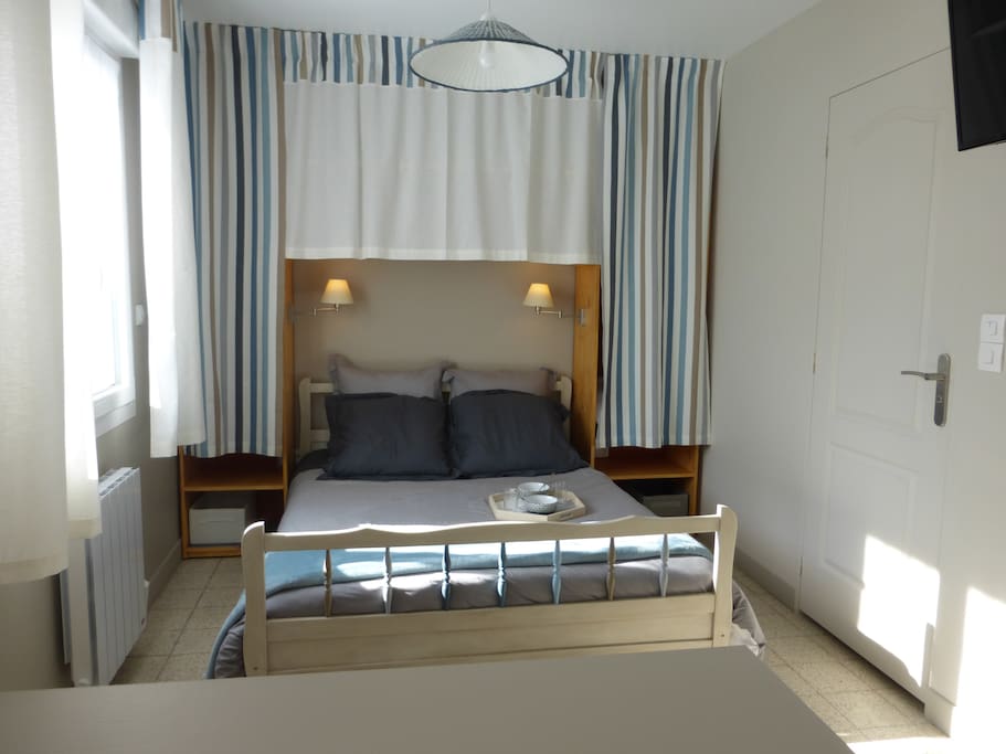 Coin chambre, lit éclairé par deux appliques, avec penderie de chaque côté du lit