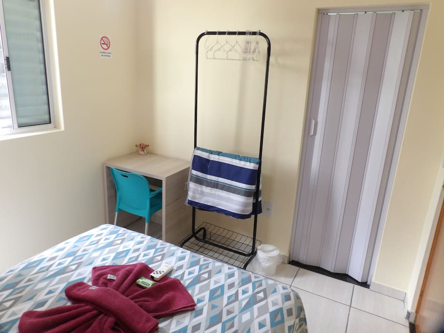 Cama de casal confortável em quarto bem iluminado.
Comfortable double-bed in a well lit bedroom.
