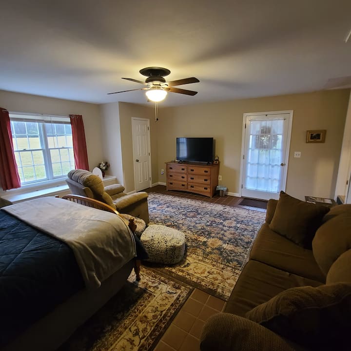 Slaapkamer met queensize bed en tv.