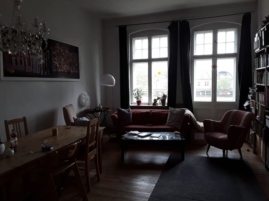 Großzügiges Wohnzimmer mit großem Esstisch und Schlafcouch
