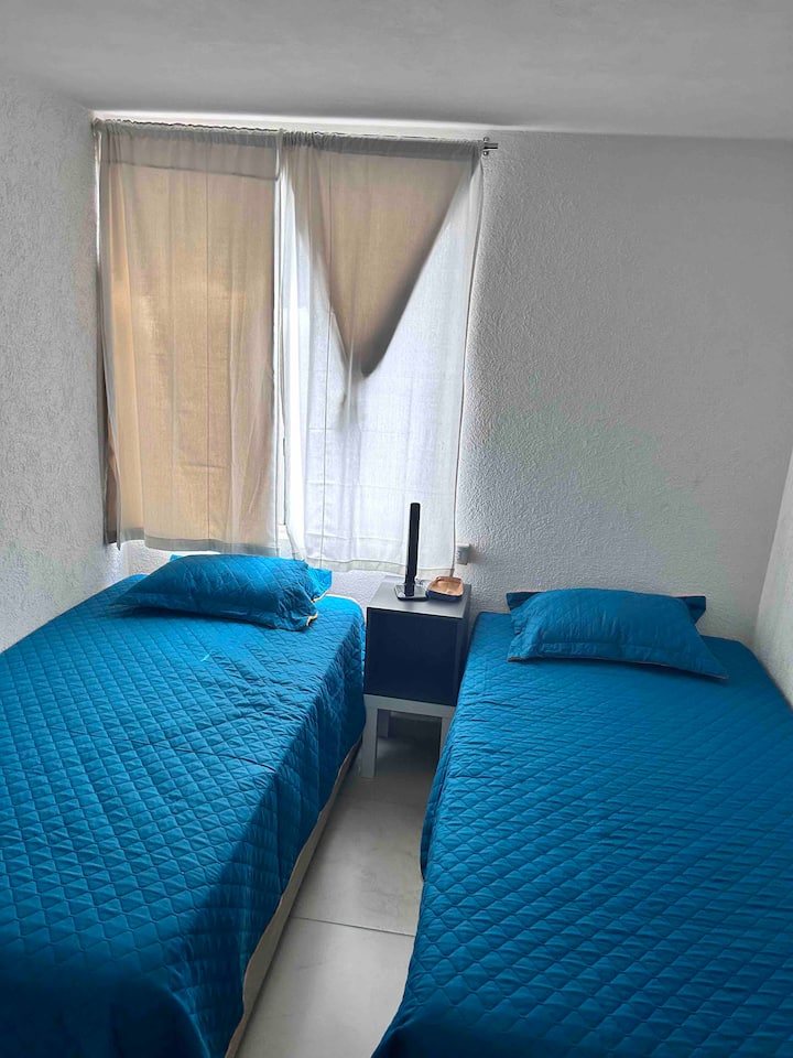 Bedroom with two twin beds, a bureau and lamp with wireless charger for cell phones, closet and banquet.