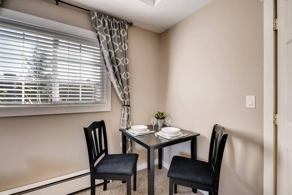 One corner of the room has a table for two that is perfect for dining.