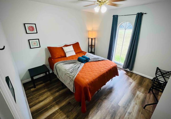 Dormitorio tamaño queen y sencillo con mesa auxiliar, lámpara y portaequipajes. El armario tiene perchas. ¡El ventilador de techo funciona muy bien! 