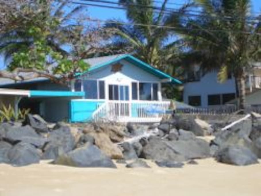 House with road in-between house and beach.