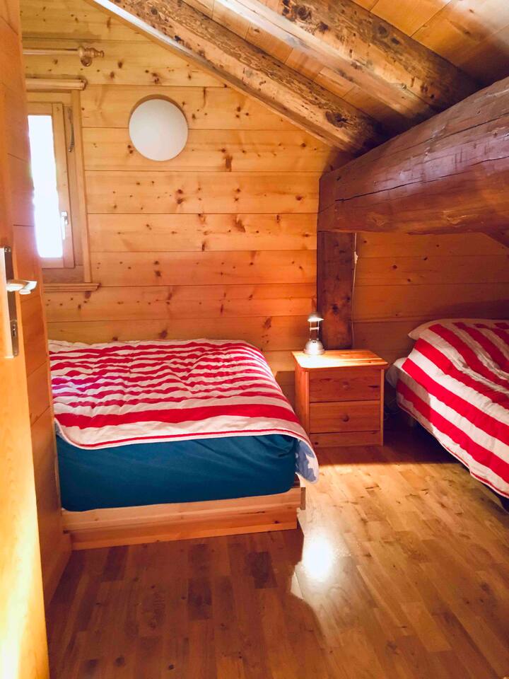 Dhomë gjumi në katin e sipërm. Krevat dopio "Queen" në të majtë dhe një krevat tek në të djathtë. Dritare me pamje nga mali për të kontrolluar motin herët.