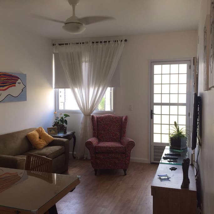 Sala no terreo com smart Tv, sofa e poltrona.