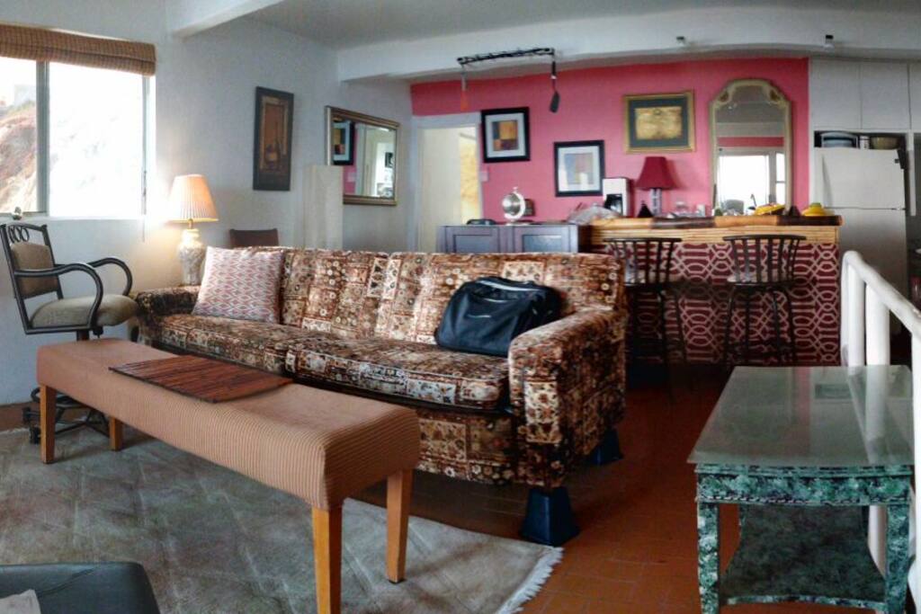 2nd story living room with small kitchen and full sized refrigerator