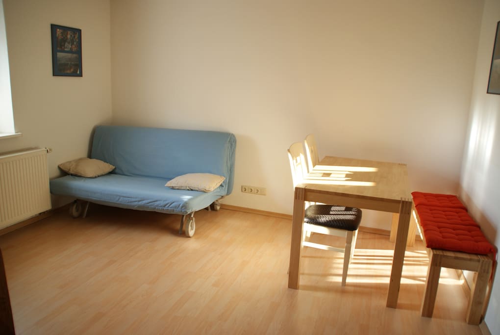 Wohnzimmer mit Schlafcouch und Esstisch