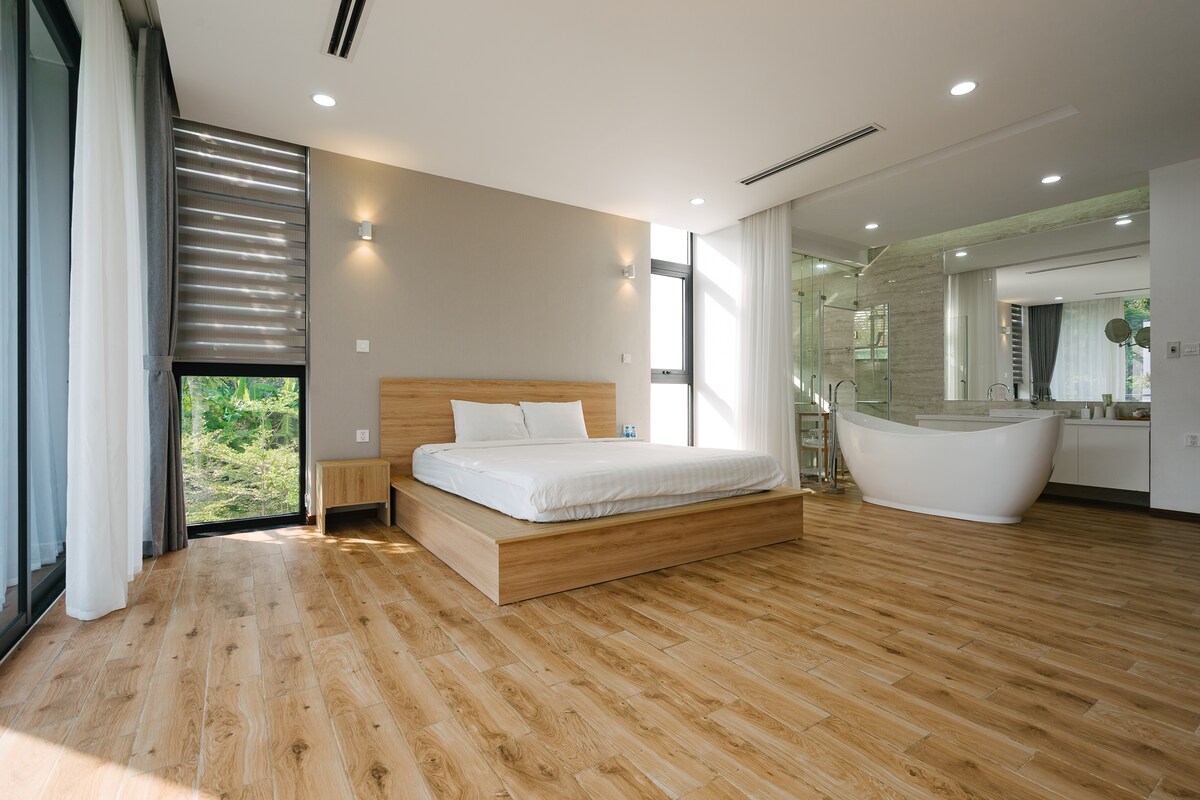 חדר שינה ראשי גדול עם אמבטיה בחלל פתוח 