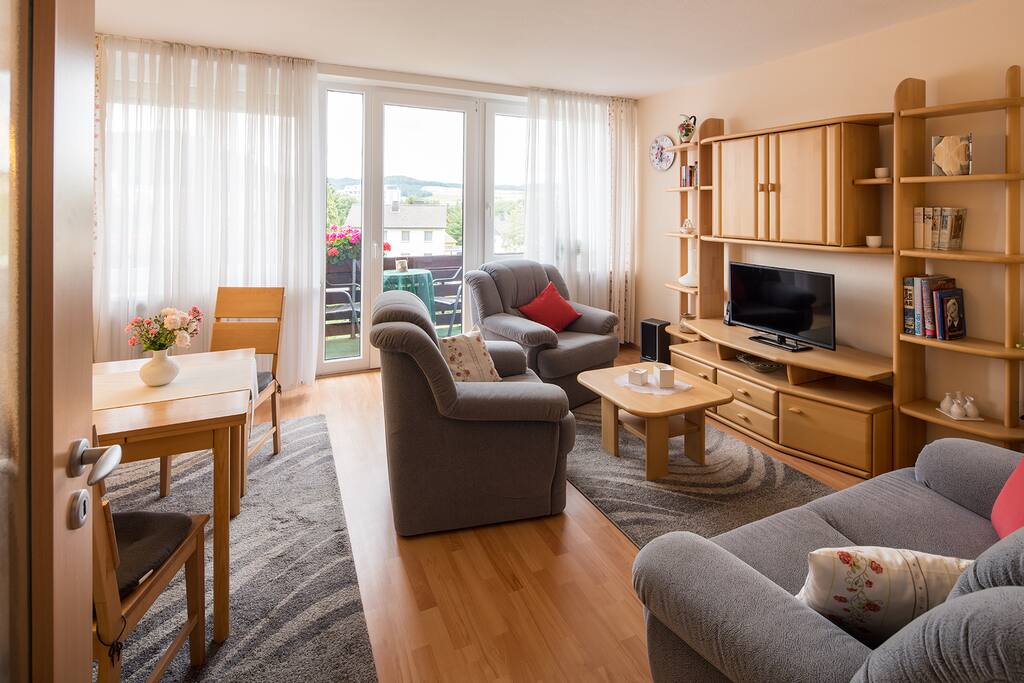 Wohnzimmer mit Essecke und Zugang zum Balkon