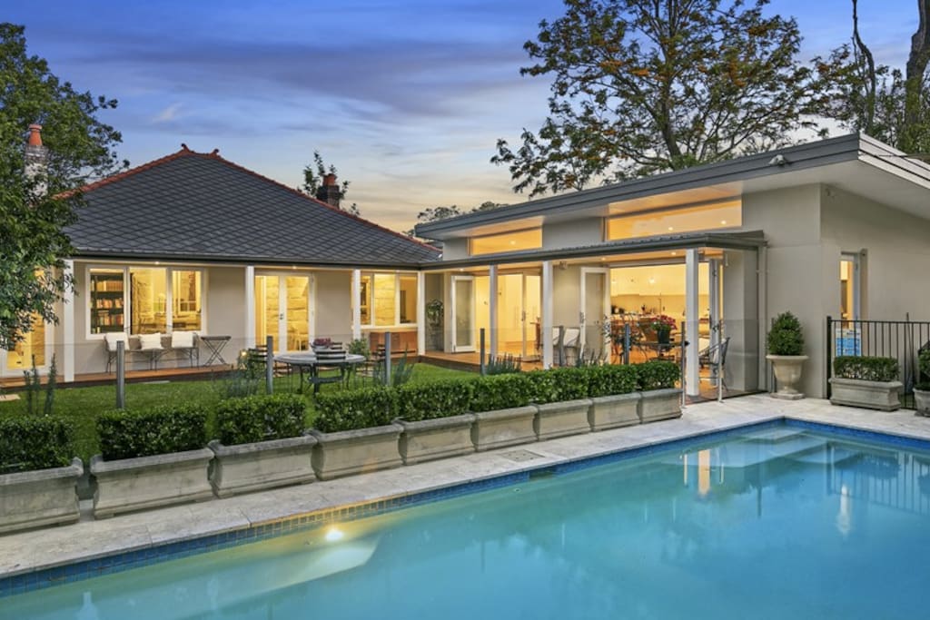 10m pool, safely surrounded by a glass fence, with sun lounges and outdoor shower.