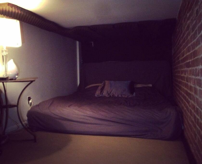 6ft X 18ft cozy exposed brick loft with incredibly large King-Size Mattress. Equipped with Mini-Fridge! Sound-proofing pads partially line the ceiling. there are very sturdy stairs to this loft. & a banister being installed unlike one of the reviews that said it's a ladder. I had them specially installed. If you neled help w luggage, someone will always help you.