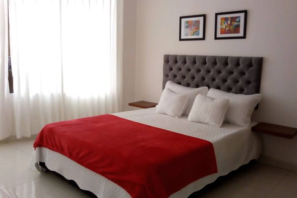 Amplias habitaciones con camas dobles, espaldares y mesas de noche, amobladas y decoradas