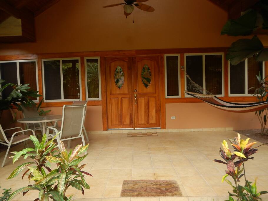 Large patio for outdoor dining. Table and chairs with hammock.