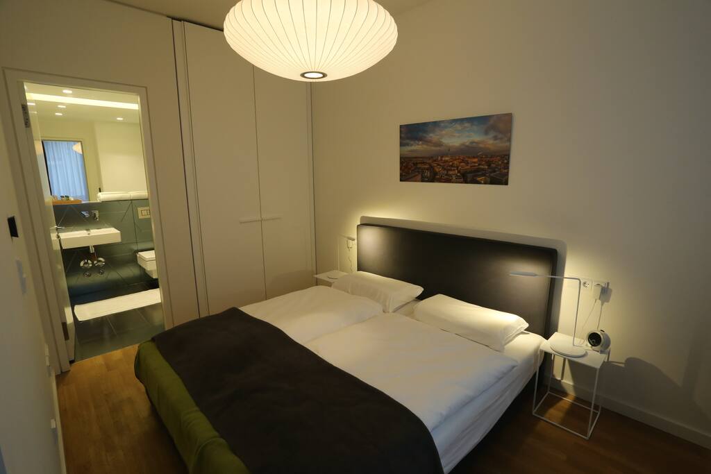 Schlafzimmer 1 mit Boxspringbett und Ensuite Duschbad