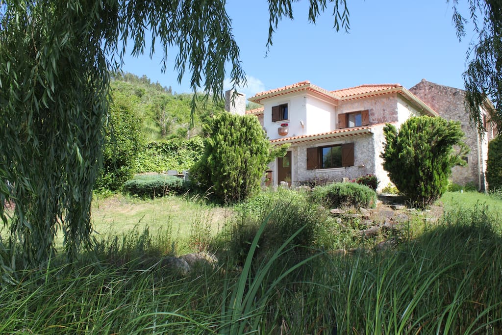 Front view of Casa Antiga seen from the pond (spring water) with koi fish.