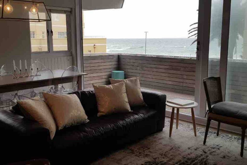 Open plan living leading onto large balcony. Television on opposite wall.