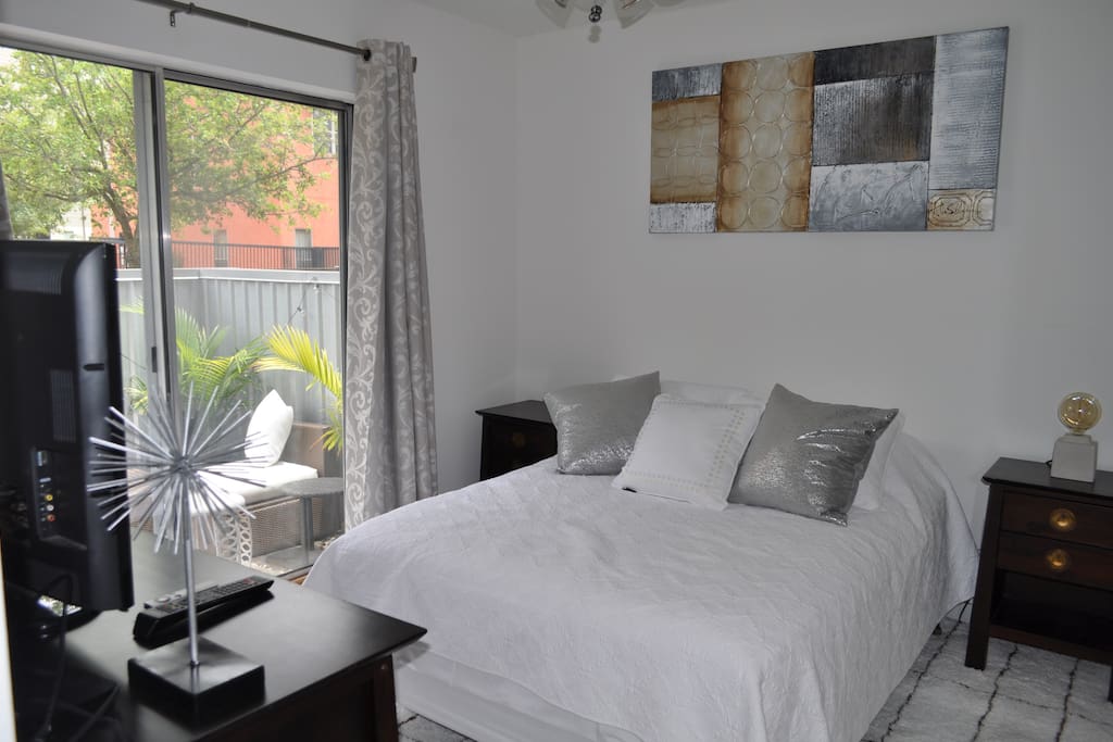 Private bedroom on first floor of townhouse with full size bed, dresser and bed side tables, both Apple TV & Roku and direct access to patio and private bathroom