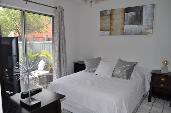 Private bedroom on first floor of townhouse with full size bed, dresser and bed side tables, both Apple TV & Roku and direct access to patio and private bathroom 