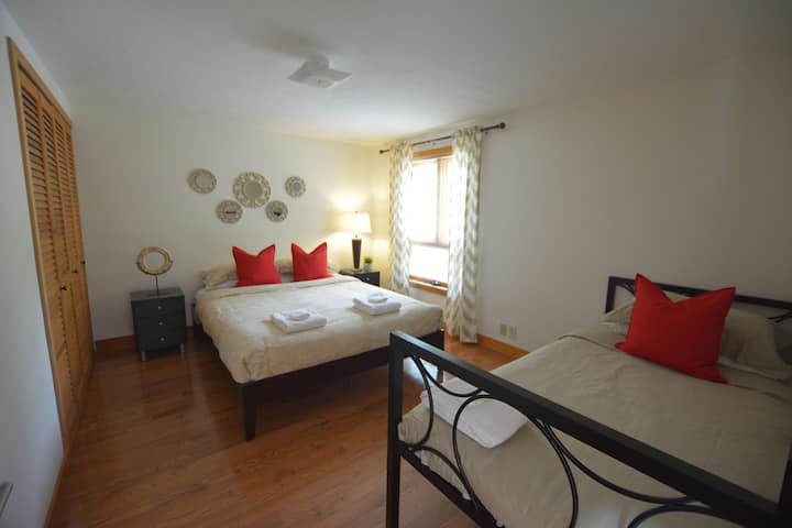 غرفة نوم في الطابق الثاني بسرير بحجم كبير وسرير نهاري بحجم مزدوج