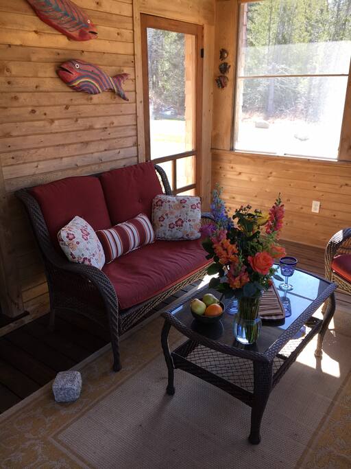 Screened porch, patio with gas grill behind and outdoor shower on other side.