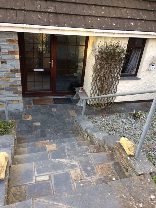 The front door of the house down the steps.
