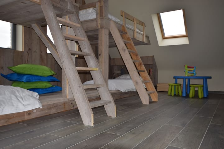 Sala de estar con cuatro camas completas y una cuna. Segunda cuna disponible a pedido. Se proporcionan juguetes y TV en la habitación.