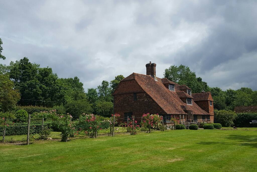Rear of our house showing cat slide roof and rose walk