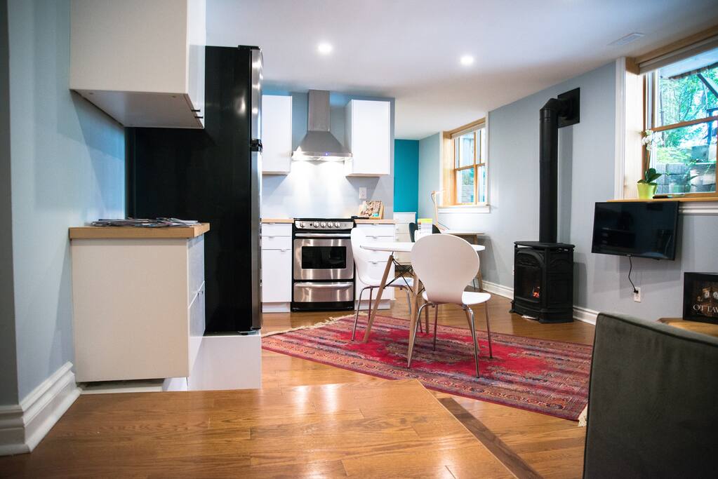 Main living space with full kitchen, gas fireplace, TV, and sofa bed.