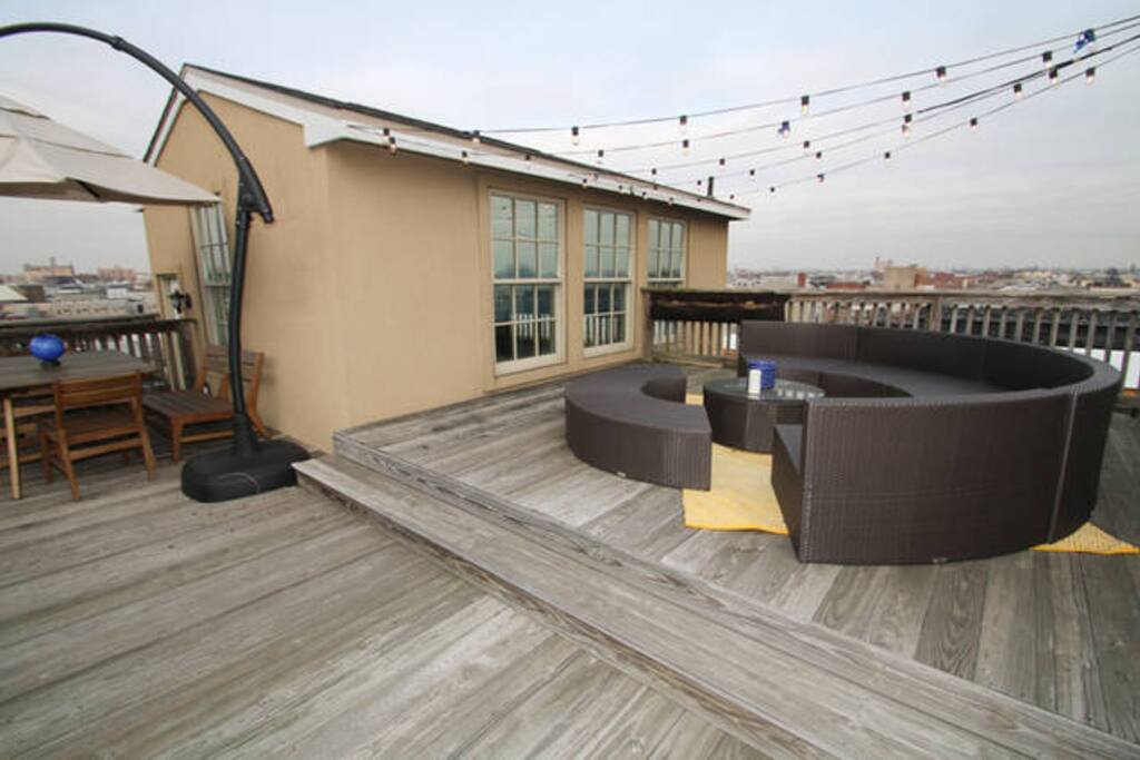 View across the private outside patio showing the sofa as well as table and umbrealla