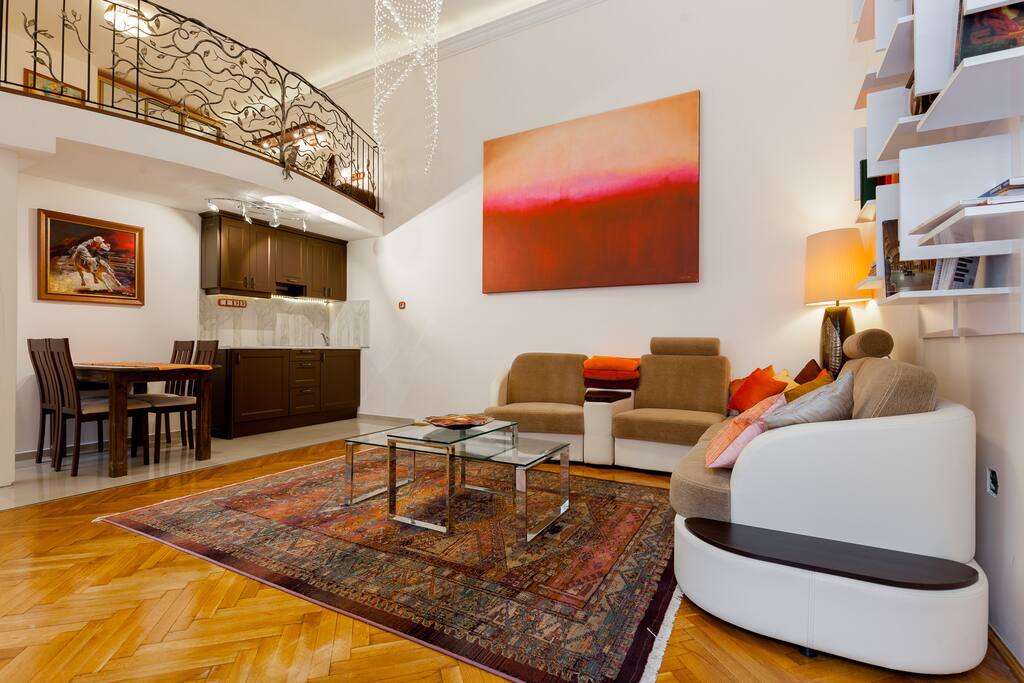 Living room, kitchen, dining area and wrought iron balustrade on mezzanine