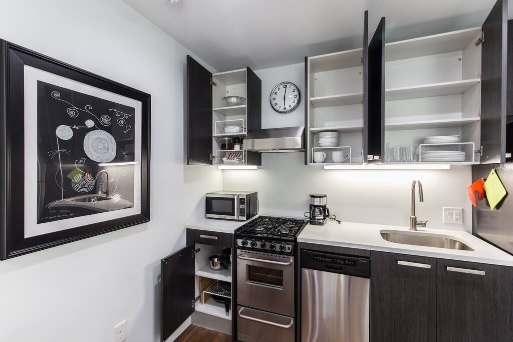 The kitchen is stocked with basic cookware and dishes, and includes a stove/oven, dishwasher, microwave, and full-size refrigerator.