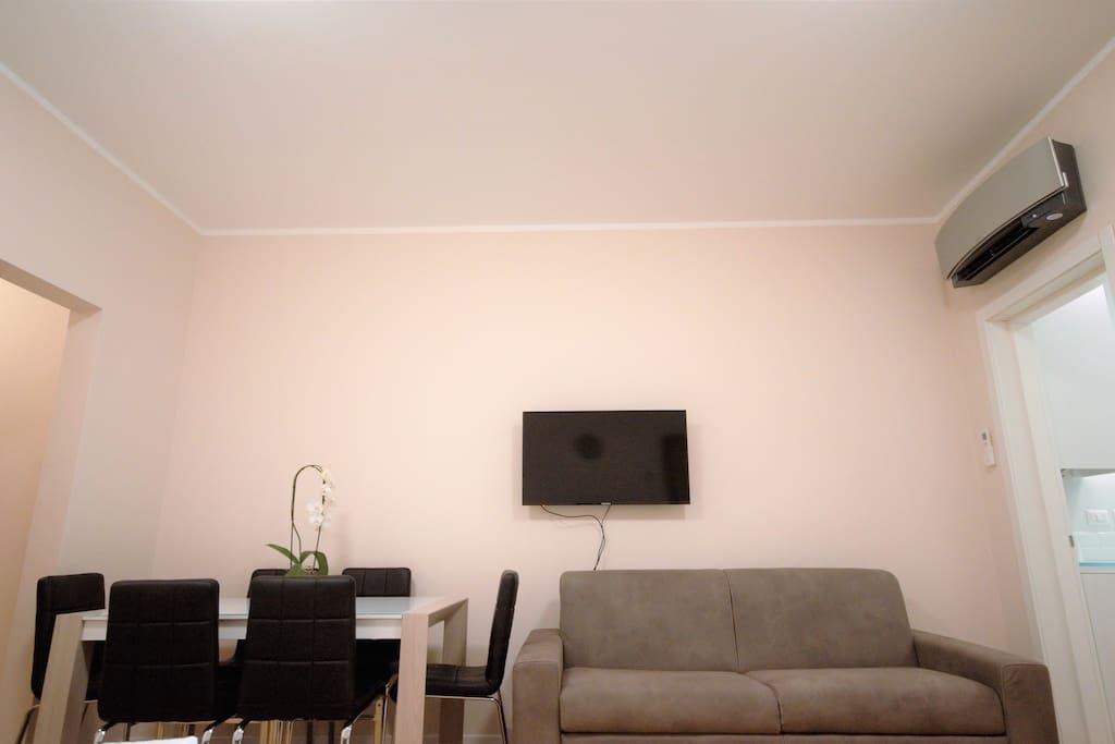 Living room with 2 sofabeds, table, chairs, Air Conditioner, window, TV, WIFI