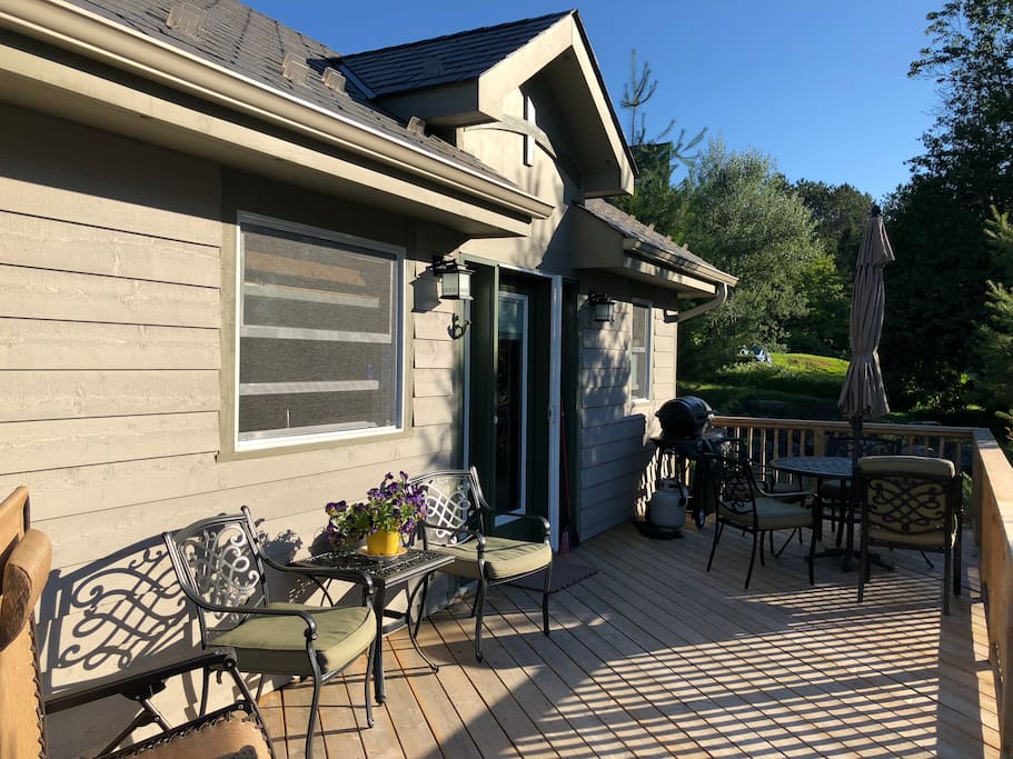 View of cottage with large, private deck, outdoor furniture, propane BBQ