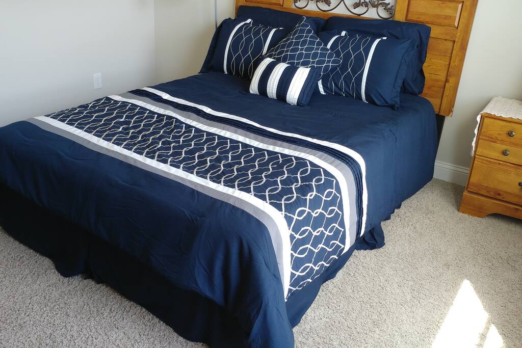 Queen size bed next to a shared full bathroom