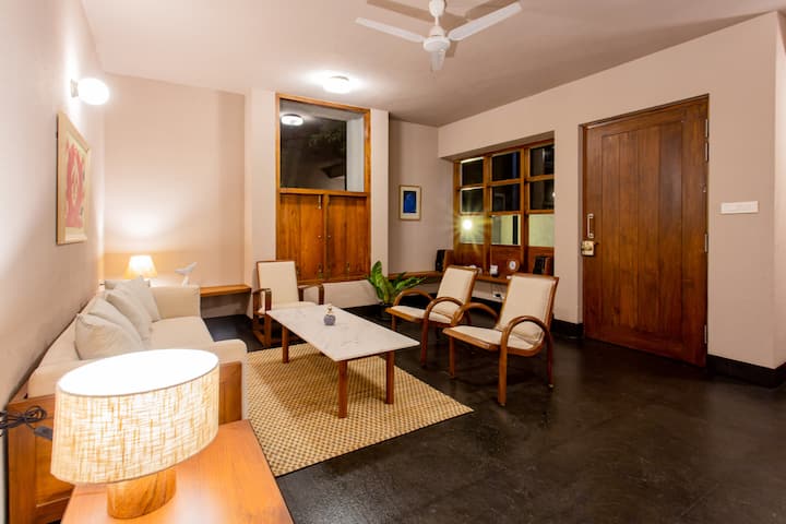 Each of the chairs in this room is an old upcycled one belonging to the colonial times. At least one chair is a family heirloom that is over a hundred years old. The clear windows look outward into the private courtyard.