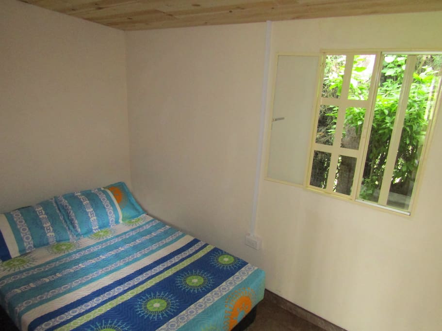 habitacion con cama matrimonial con una comoda