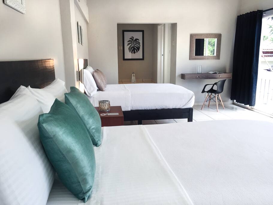 Decoración neutra y camas con ropa de algodón suave de gran calidad para un mejor descanso