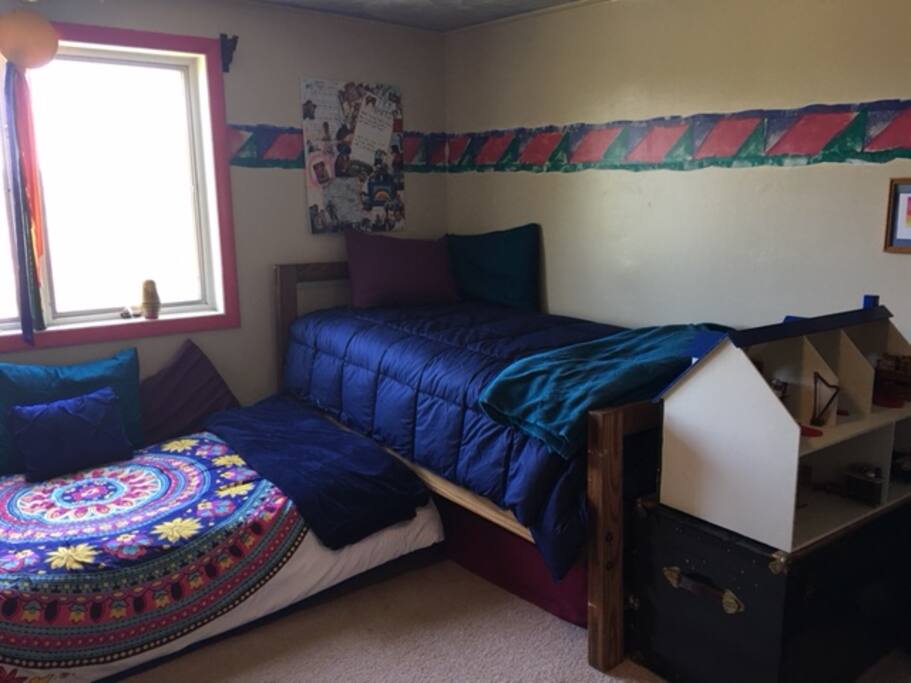 A playful and kid-friendly room with two furnished dollhouses to play with.