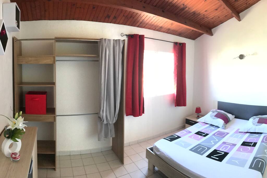 Chambre 1 comportant un lit 160x200 ainsi qu'un grand dressing et une commode pour un confort optimal.