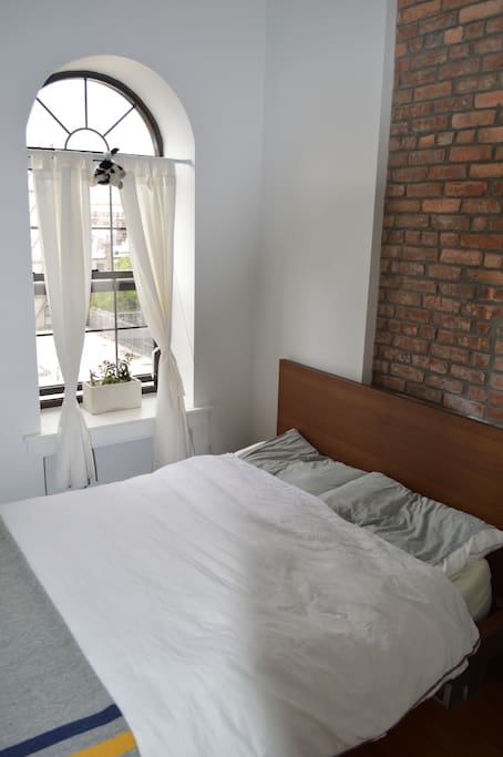 Queen bed with Helix Mattress and large bay window.
