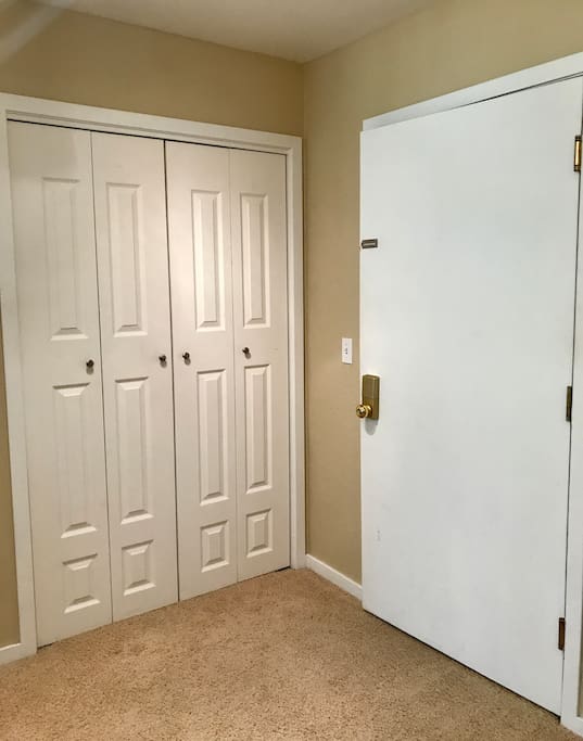 Large entry closet with hangers and space for storage.