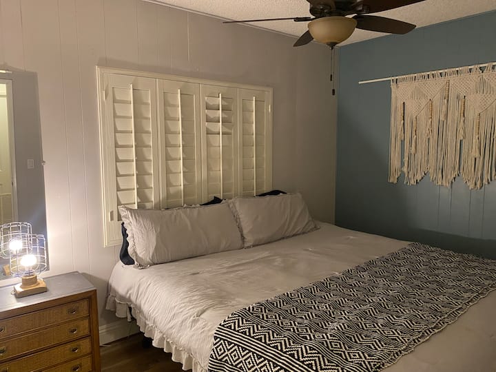 تحتوي غرفة النوم الثالثة على سرير بمقاس كبير ومروحة سقف ومرآة كاملة الطول.