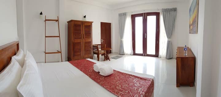 キングサイズのベッドを備えたベッドルーム、オーシャンビュー、庭へのアクセス。 