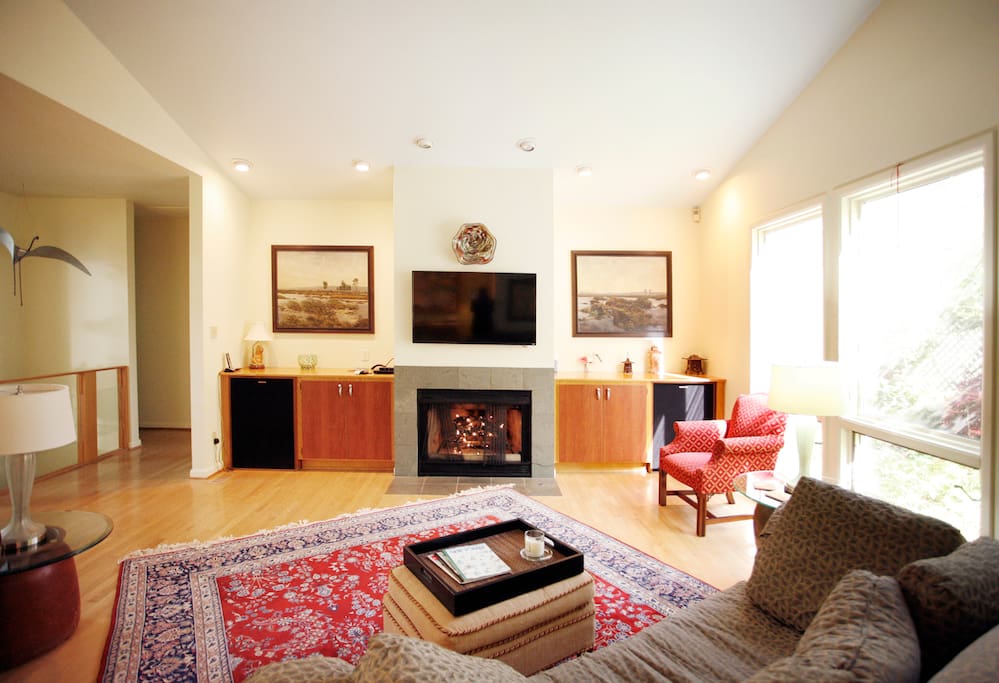 Open living room, with flat-screen smart TV. The hallway to master suite and office/library is to the left.