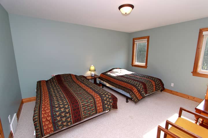 Spálňa pre hostí na hornom poschodí s detskou postieľkou