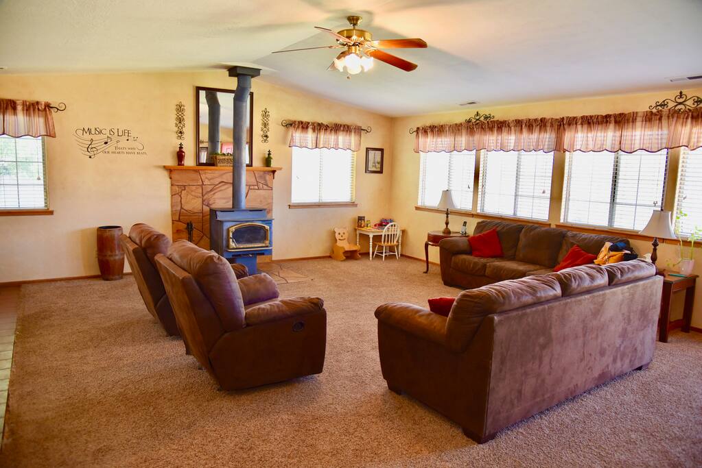 A spacious living room with plenty of seating around a fireplace.