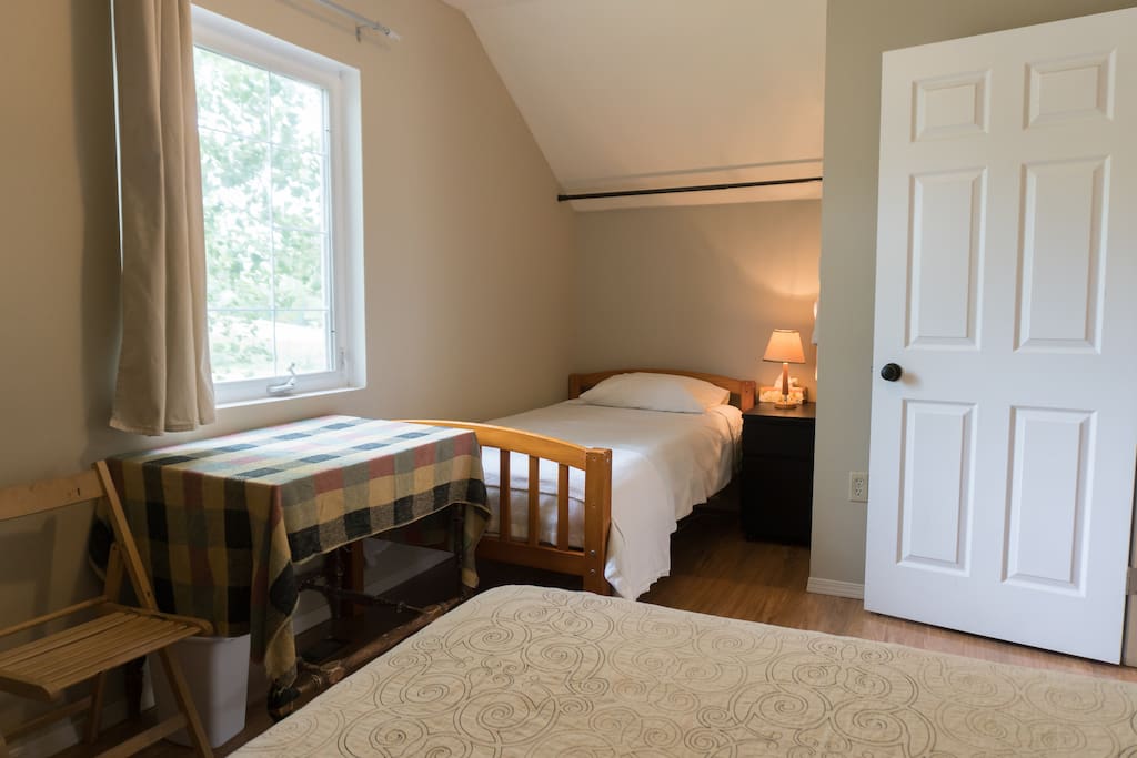 Private room with two beds, dresser and table. Twin bed can be used as a day couch
