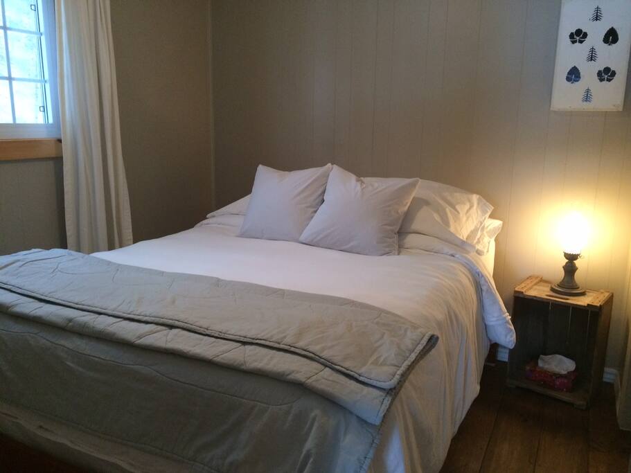 Comfortable queen size bed with lots of fluffy pillows / Un grand lit avec plusieurs oreillers.